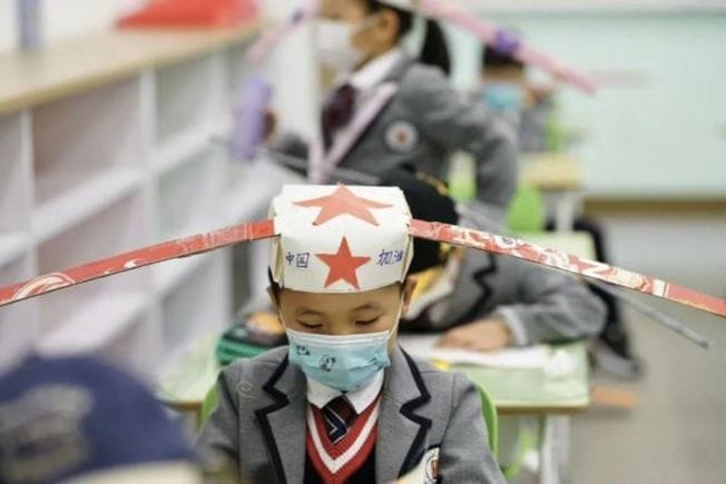 В Китае дети вернулись в школы и носят особые шляпы. Они нужны, чтобы научить школьников держать дистанцию 25