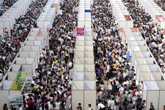 Тысячи лиц ищущих работу рассматривают стенды на ярмарке вакансий в городе Чунцин