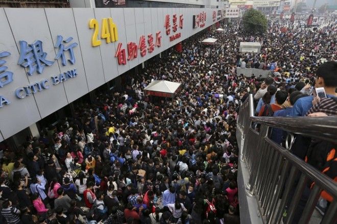 Пассажиры на переполненном железнодорожном вокзале Чжэнчжоу в первый день праздника по случаю годовщины Дня образования КНР