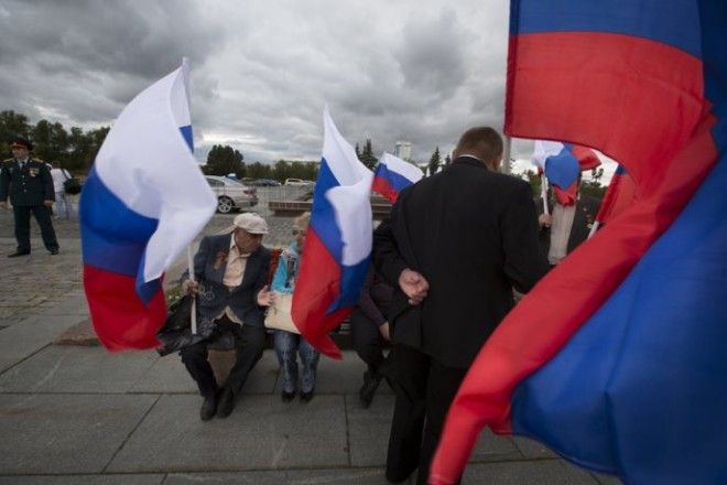 People holding Russian flags gather to mark National Flag Day in Moscow Friday Aug 22 2014 The holiday introduced in 1994 is marked annually to commemorate the first time in 1991 when threecolor flag was hoisted over the Russian government building to replace the Soviet hammer and sickle flag after Russias failed 1991 coup AP PhotoAlexander Zemlianichenko ORG XMIT MOSB103