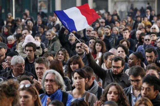 A man waves a French flag as several hundred people gather to observe a minute of silence in Lyon France November 16 2015 to pay tribute to the victims of the series of deadly attacks in Paris on Friday REUTERSRobert Pratta